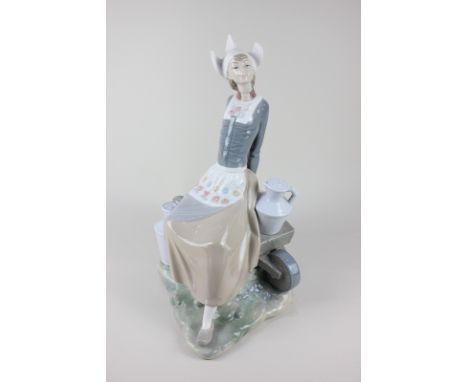 A Lladro porcelain figure of a seated milkmaid with cart and two jugs, 34cm high