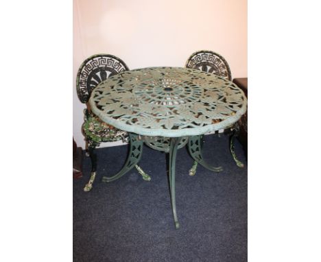 A green painted metal garden table with circular pierced top and under-shelf, 89cm, together with two green painted metal gar