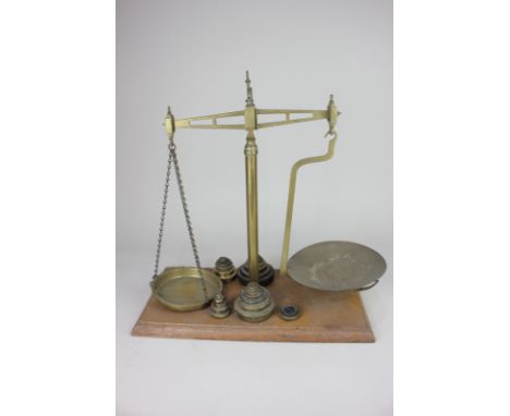 A set of brass balance scales on wooden base with weights