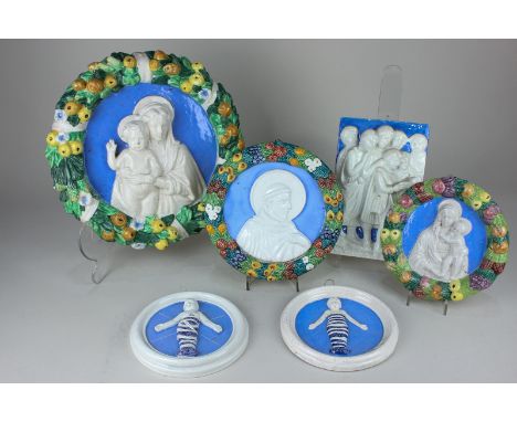 A collection of six Italian Della Robbia style wall plaques, moulded in high relief, to include the Madonna and child within 