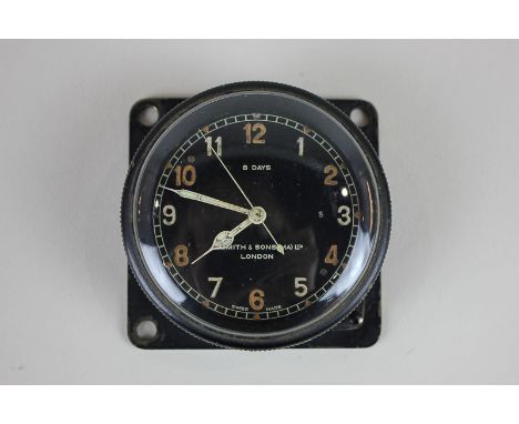 An aviator's clock, by repute from an aeroplane control panel, with circular black dial, with outer ring winder and button ad