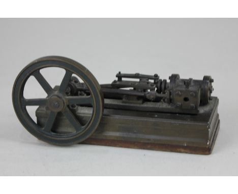 A 19th century miniature table top model of a steam engine with turning wheel and piston, mounted on wooden base with inscrib