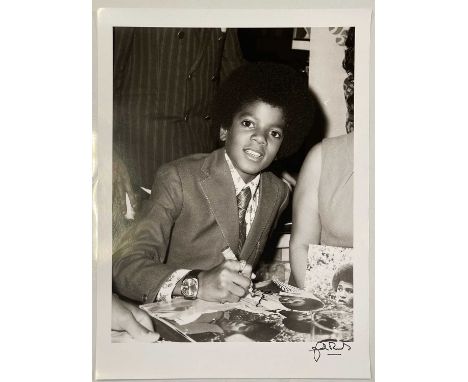A high-quality photo print of a photograph by John Rowlands depicting a youthful Michael Jackson during a signing session in 