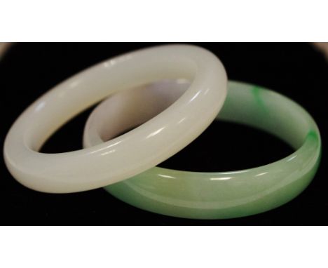 A Chinese pale celadon jade bangle, 7.5cm diam;  another (2)