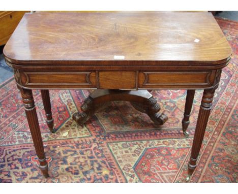 A Regency mahogany card table, rounded rectangular top opening to green baize playing surface, turned and reeded legs, brass 