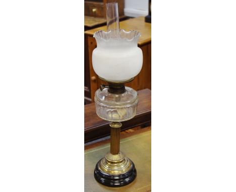 A Victorian oil lamp, clear glass reservoir, reeded brass column, circular base.