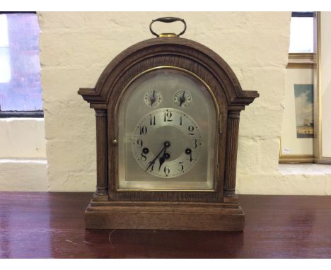 An oak cased Westminster chime mantle clock with fluted column decoration.