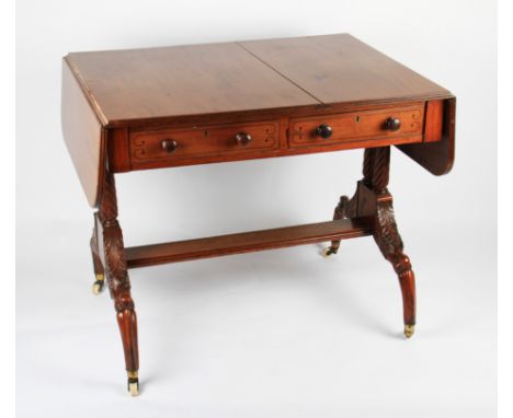 A Victorian mahogany sofa table with two fitted drawers and two false drawers on twist pillars and shaped supports with ceram