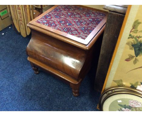 A Victorian mahogany lift top commode with embroidered top.