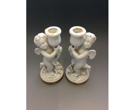 A pair of ceramic lamp bases in the form of cherubs.