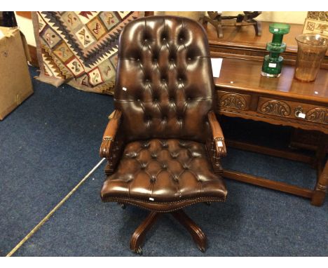 A brown leather button-backed mahogany framed office chair with wheels