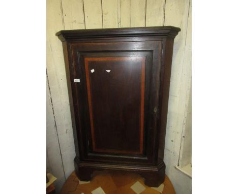 Edwardian crossbanded and inlaid mahogany floor standing corner cabinet with fielded panel door and bracket feet 