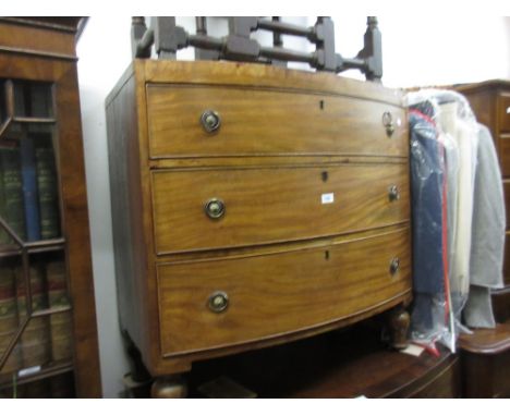 Small Regency mahogany bow front chest of three graduated drawers with brass ring handles raised on low baluster supports, 35