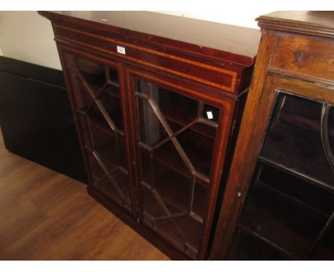 Edwardian mahogany and inlaid bookcase with a pair of astragal glazed doors raised on a plinth base 