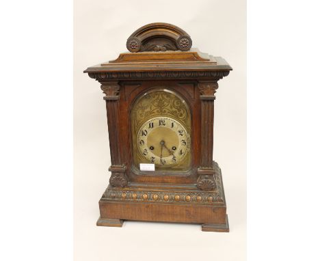 Late Victorian walnut bracket clock, the arched dial with Arabic numerals with a two train movement striking on gongs, togeth