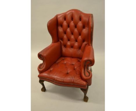 Pair of red button leather upholstered wing back armchairs raised on low cabriole claw and ball front supports 