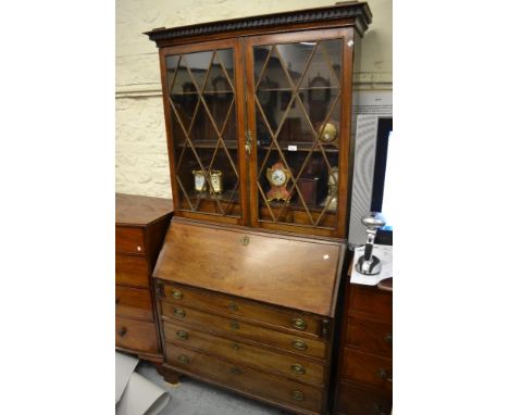 19th Century mahogany bureau bookcase having a moulded key pattern cornice above two astragal glazed doors enclosing adjustab