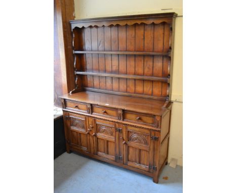 Good quality reproduction oak dresser, the boarded shelf back above three drawers and three carved and panelled doors on stil