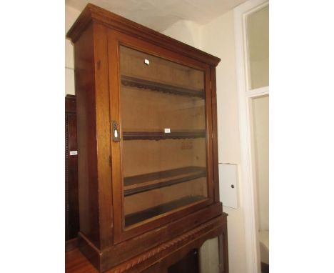 Late Victorian mahogany bookcase with a single glazed door enclosing shelves on a plinth base 