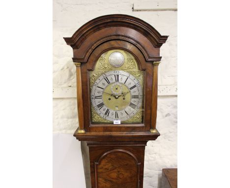 Figured walnut longcase clock, the broken arch hood with flanking pilasters above a moulded panel door and conforming plinth 