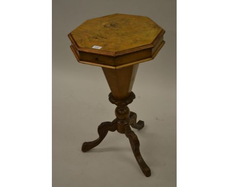 Victorian figured walnut octagonal trumpet form work table, the hinged cover enclosing a fitted interior above a carved tripo