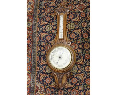 Late 19th or early 20th Century carved oak aneroid barometer / thermometer with enamel dials 