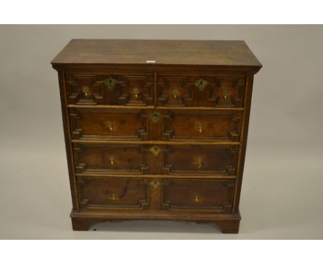 Late 17th or early 18th Century oak moulded front chest of two short and three long drawers with brass drop handles and escut