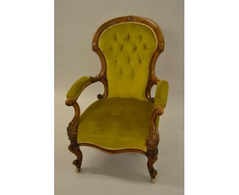 Victorian walnut spoon back elbow chair with gold button upholstered back, upholstered seat and arms, raised on carved cabrio