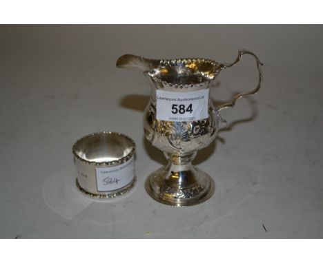 George III floral embossed silver cream jug together with a silver napkin ring 