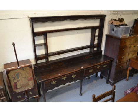 18th Century oak dresser with a shelf back above two frieze drawers with brass swan neck handles raised on turned supports wi