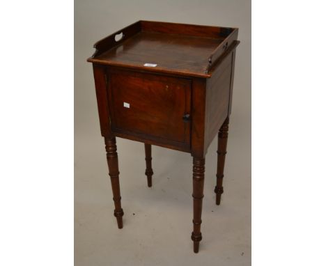 Early 19th Century mahogany bedside cabinet with a tray top above a single door on ring turned tapering supports 