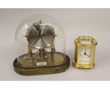 Kundo brass Anniversary clock under a glass dome, together with a modern brass cased carriage clock 