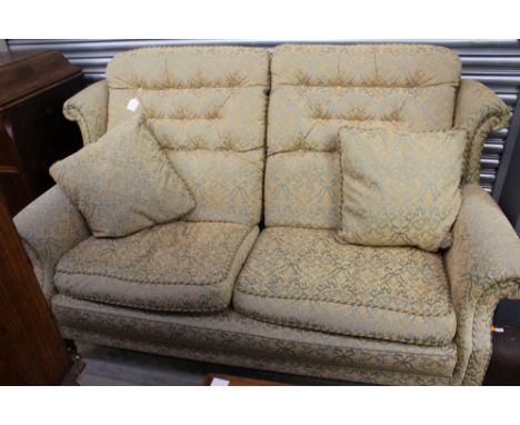 A classic three piece suite, with foliage patterned upholstery, comprising a two seater settee and two matching armchairs, al