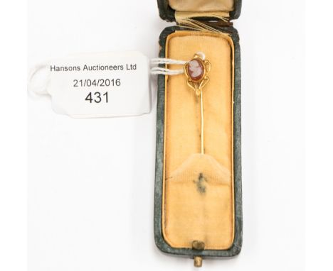 A yellow metal stick pin with inset cameo terminal in presentation case 