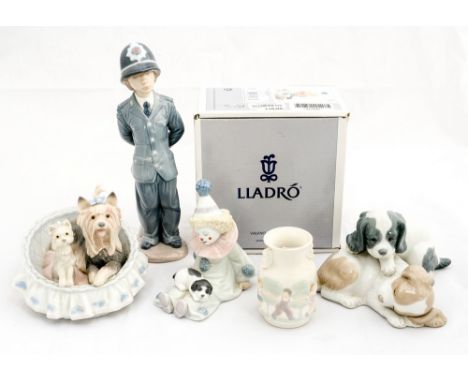 A boxed Lladro clown, with a Lladro policeman, dog in basket, matt finish twin handled vase and Nao puppies (5)