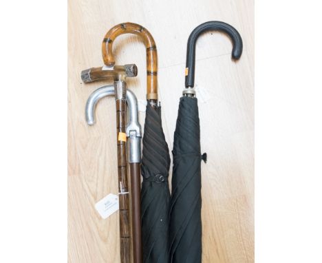 An early 20th Century silver capped, horn handled walking stick with a bamboo stick, together with two walking sticks, umbrel