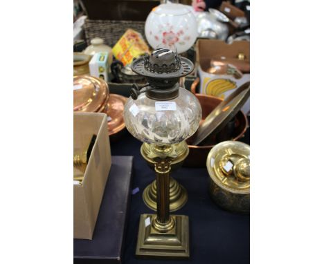 A twin burner oil lamp, having brass base, and cut glass reservoir, with chimney