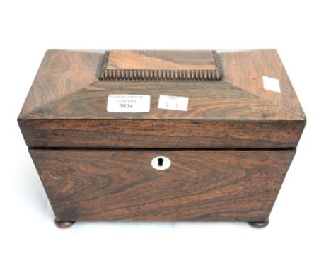 A Victorian sarcophagus shaped mahogany tea caddy with ball feet and fitted interior 