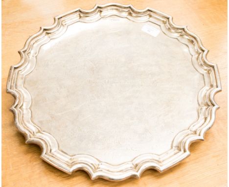 A George V silver salver in the George II style with Chippendale border, on three acanthus scroll feet, engraved with present