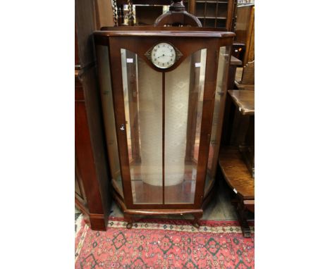 An early 20th Century walnut display cabinet, the glazed door fitted with a Smith's clock