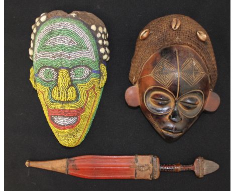 Two African tribal masks with shell decoration and a small native dagger.
