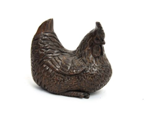 A Japanese carved wood netsuke, Meiji, in the form of a nesting chicken, inset seal mark to the underside, approx. 5cm long 