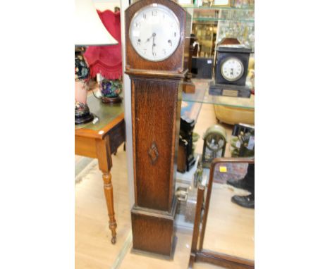 An early 20th Century oak grand daughter clock, having an eight day movement, with a white enamelled dial and black Arabic nu