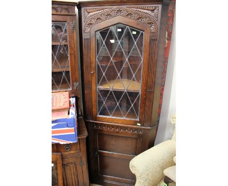 A Jacobean style oak dresser, with lead glazed doors to upper section and a shelf to centre, the base with four drawers over 