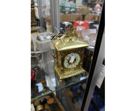 A brass embossed mantle clock, enamelled face Arabic numerals, with two Bayard carriage clocks, one in need of restoration, a