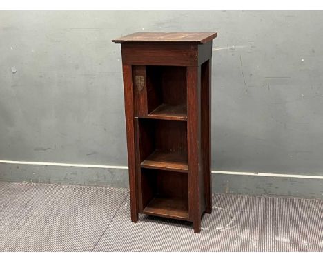 A stained wood open bookcase with Cambridge University metal mount, with three front and one side shelf, numerically stamped 