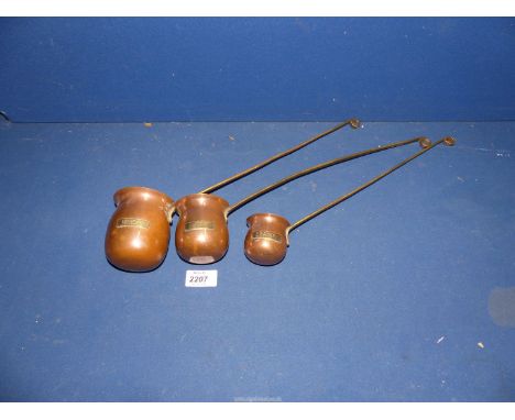 Three copper and brass drinks ladles, "Brandy", "Rum" and "Whisky".