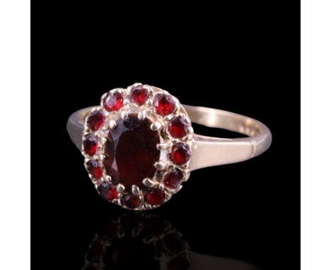 A vintage garnet oval cluster ring, the central stone of approx 1 ct, set on 9 ct gold, R, 2.1 g