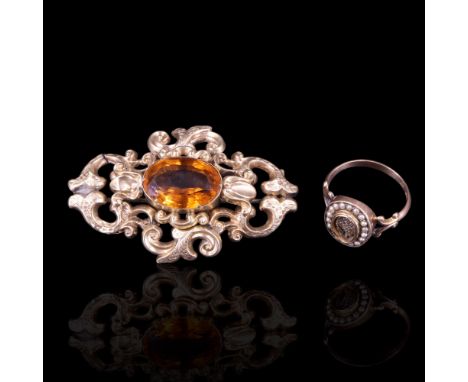 A Victorian seed pearl locket ring comprising a central oval of plaited hair surrounded by an oval bezel of seed pearls, set 