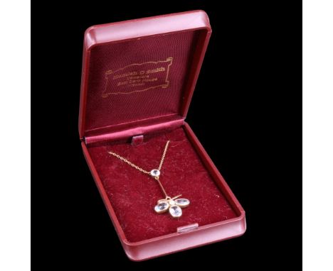 An aquamarine and pearl pendant comprising three oval-cut stones, millegrain-set in a petal-like arrangement around a pearl o